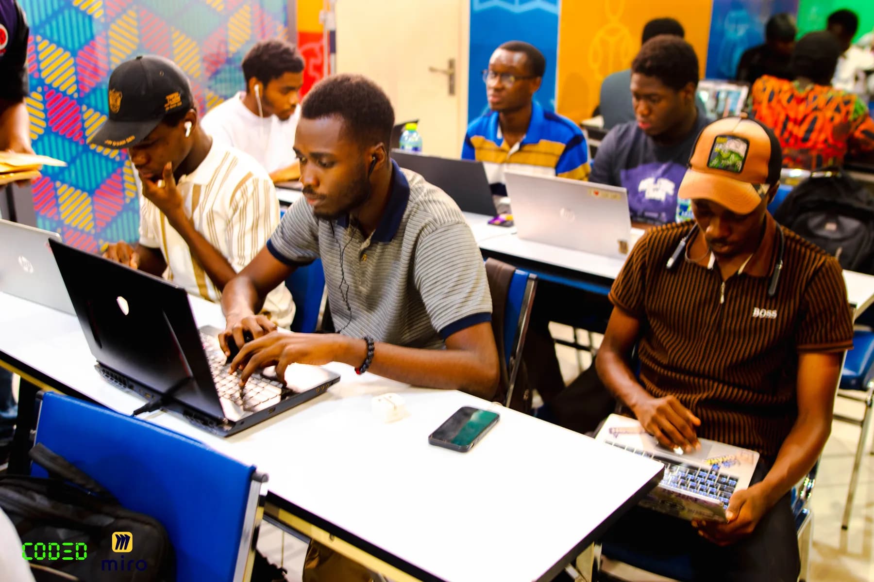 Builders working on laptops together at a CODED event