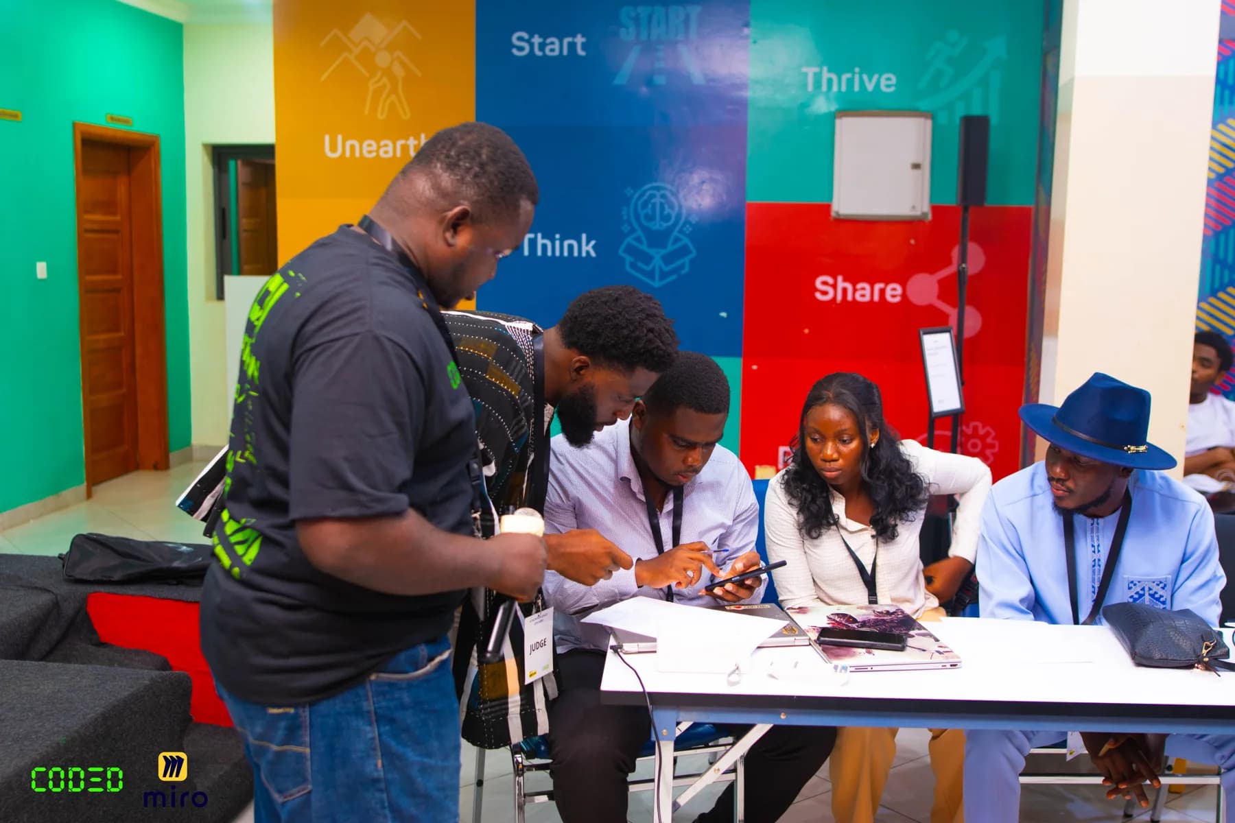 A group discussing work around a table at a CODED event